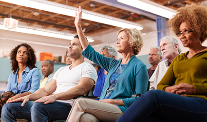 woman with hand up to ask question