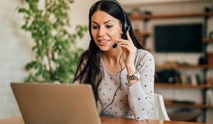 woman with headset on laptop