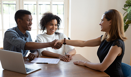 couple shaking hands with businesswoman